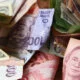 high angle shot pile banknotes from different countries wooden surface1