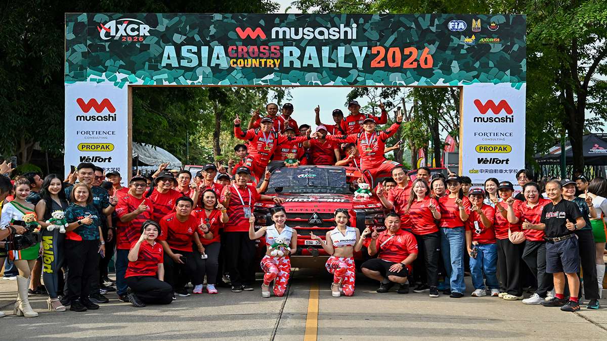 Duet Balap Florist dan Dokter Gigi Resmi Taklukkan AXCR 2026 51 Duet Balap Komunitas Dunia se Asia, Tim reli Asia Cross Country Rally 2026 berpose bersama di depan mobil balap dan papan latar acara