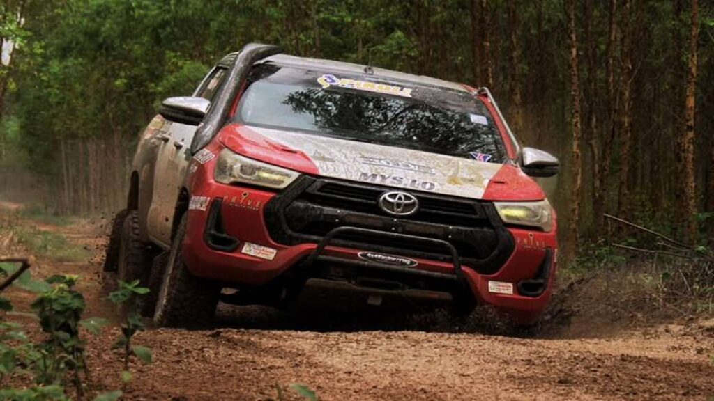 Duet Balap Florist dan Dokter Gigi Resmi Taklukkan AXCR 2026 52 Duet Balap Dunia se Asia, Mobil 4x4 merah melaju di jalan tanah berlumpur di tengah hutan