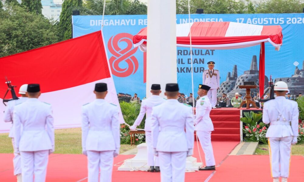 Pasukan pengibar bendera pusaka mengenakan seragam putih dalam upacara kemerdekaan di hadapan inspektur upacara