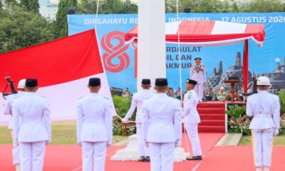 Pasukan pengibar bendera pusaka mengenakan seragam putih dalam upacara kemerdekaan di hadapan inspektur upacara