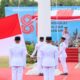 Pasukan pengibar bendera pusaka mengenakan seragam putih dalam upacara kemerdekaan di hadapan inspektur upacara