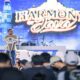 Seorang pria berdiri di atas panggung di depan layar bertuliskan Harmony of Java, berbicara di hadapan penonton yang memadati area