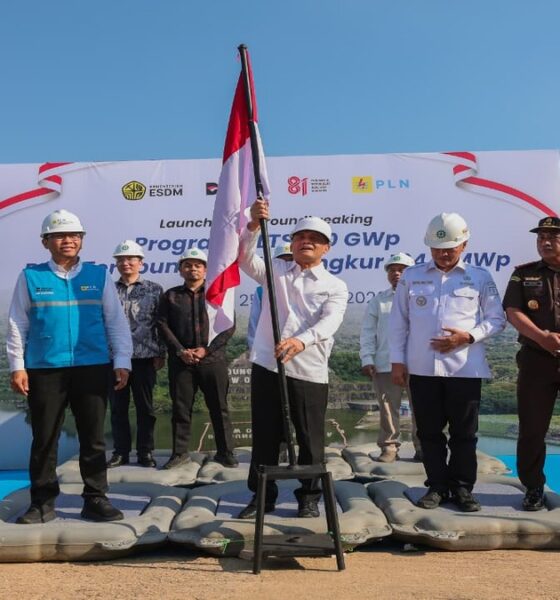 Menteri ESDM memegang tiang bendera Merah Putih dalam acara peluncuran dan peletakan batu pertama PLTS, didampingi pejabat dan aparat keamanan