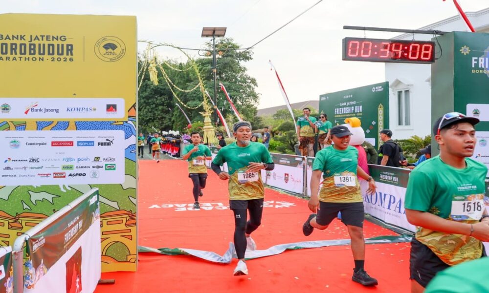 Para pelari memasuki garis finish pada ajang maraton dengan timer digital menunjukkan waktu 00:34:08