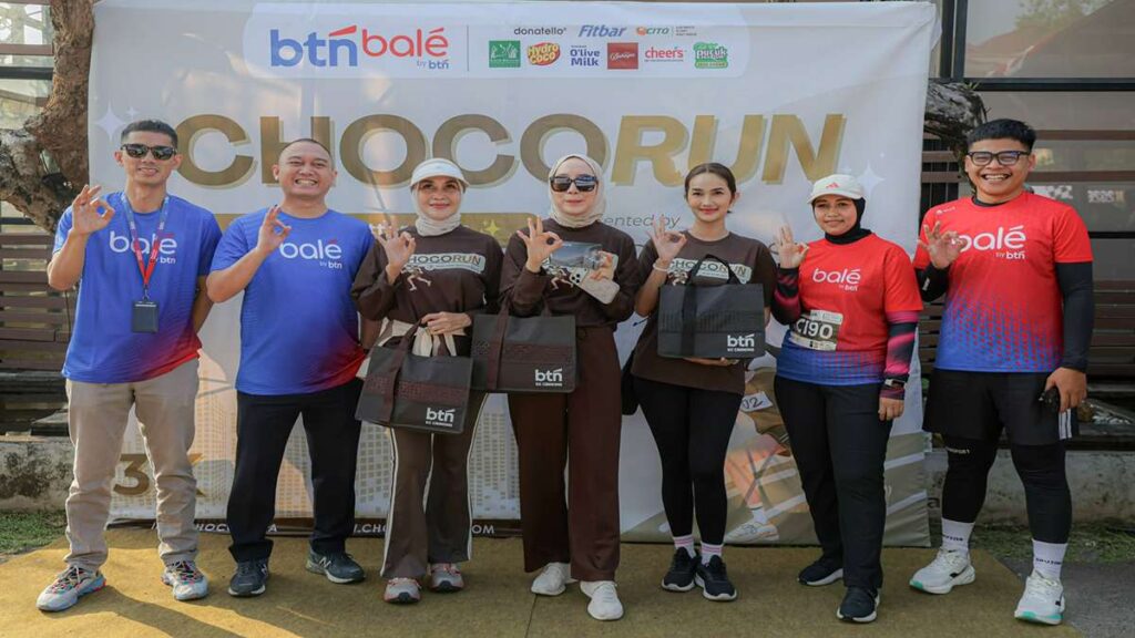 ChocoRun 2026 Sukses Digelar Yantie Rachim Perkuat Runner City 53 Chocorun 2026 Di kota Bogor Runner city, Tujuh peserta berpose di depan latar belakang Chocorun dengan mengenakan pakaian olahraga dan membawa tas goodie bag BTN