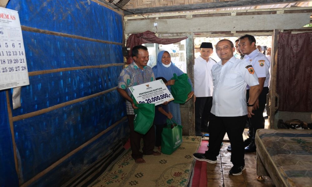 Penyerahan bantuan rehab rumah tidak layak huni dan paket sembako kepada warga di dalam rumah sederhana