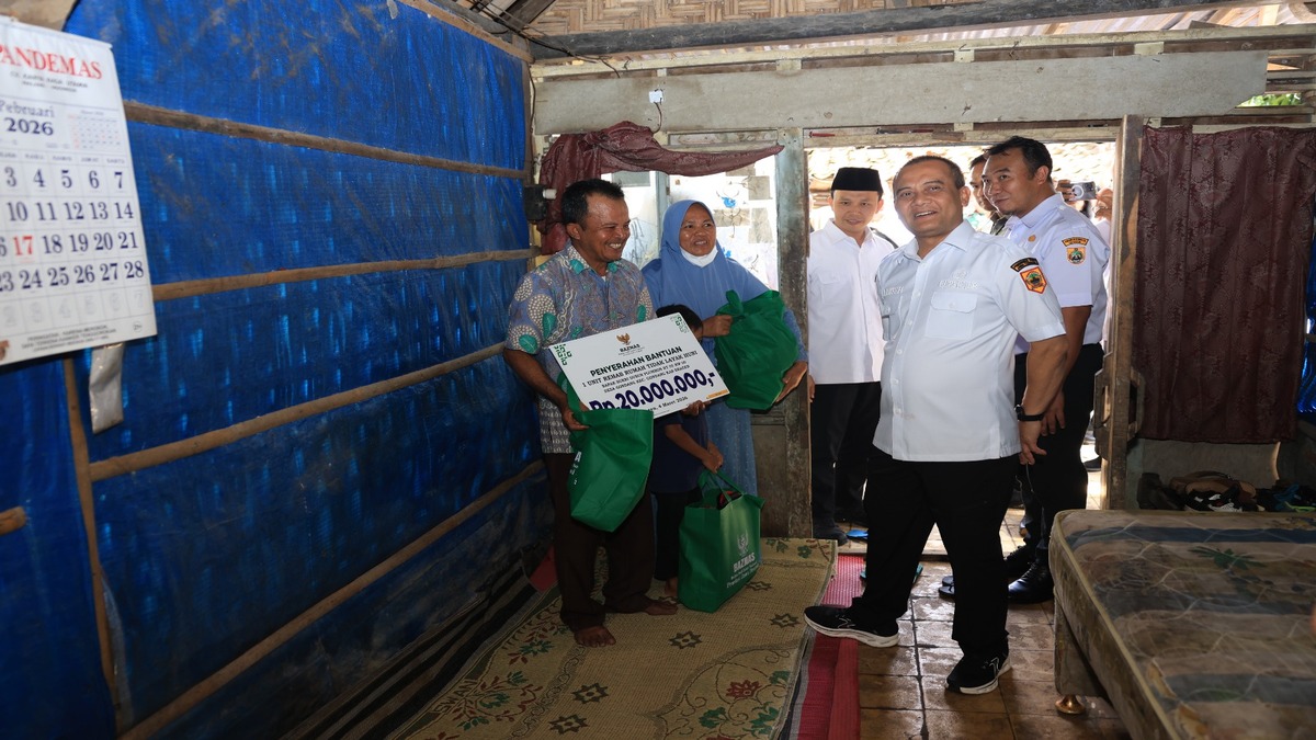 Penyerahan bantuan rehab rumah tidak layak huni dan paket sembako kepada warga di dalam rumah sederhana