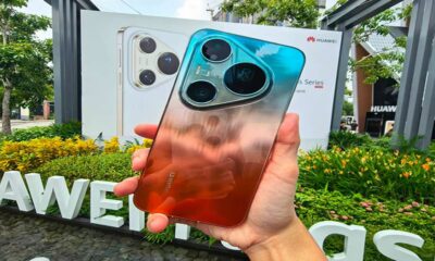 Seseorang memegang smartphone Huawei berwarna gradasi jingga dan biru dengan modul kamera segitiga menonjol di bagian belakang