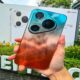 Seseorang memegang smartphone Huawei berwarna gradasi jingga dan biru dengan modul kamera segitiga menonjol di bagian belakang