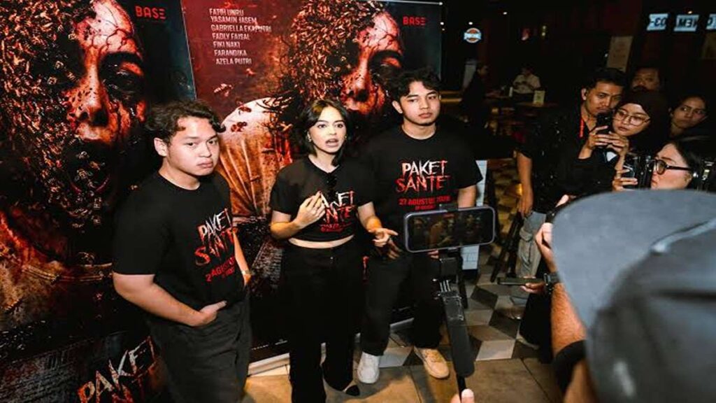 Pemeran film Paket Santet berpose di depan poster film saat acara promosi