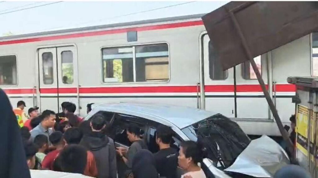 Mobil Tertemper KRL di Karet Jakpus, KAI Pastikan Tidak Ada Korban Jiwa 52 Mobil silver yang mengalami kecelakaan tertabrak kereta commuter line, dikerumuni oleh warga di lokasi kejadian