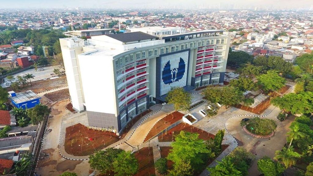 Tampak udara gedung utama kampus dengan halaman luas dan lanskap hijau di sekitarnya