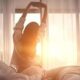 Waspada! 5 Kebiasaan Pagi Merusak Otak Walau Anda Sudah Tidur Cukup 62 Seorang wanita meregangkan tangan di tempat tidur saat matahari terbit di dekat jendela kamar