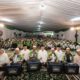 Suasana acara kebersamaan dan pembagian bantuan di dalam tenda besar yang dihadiri banyak peserta dan pengemudi ojek online