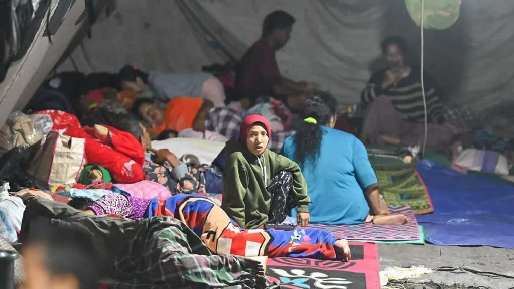Korban Gempa Nagekeo Meninggal Akibat Asma, Beberapa pengungsi tampak beristirahat dan duduk berdesakan di dalam tenda darurat yang minim penerangan
