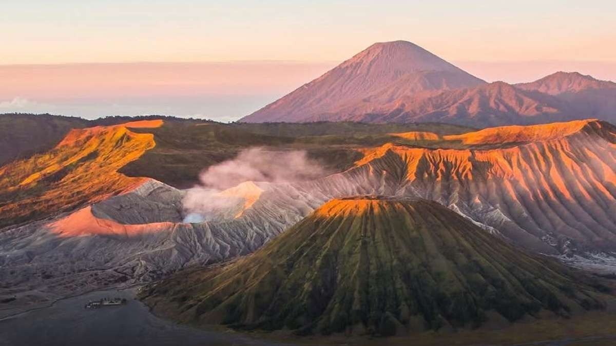 Wisata bromo kembali dibuka usai kebakaran, Pemandangan lanskap Gunung Bromo saat matahari terbit dengan kepulan asap dari kawah aktifnya