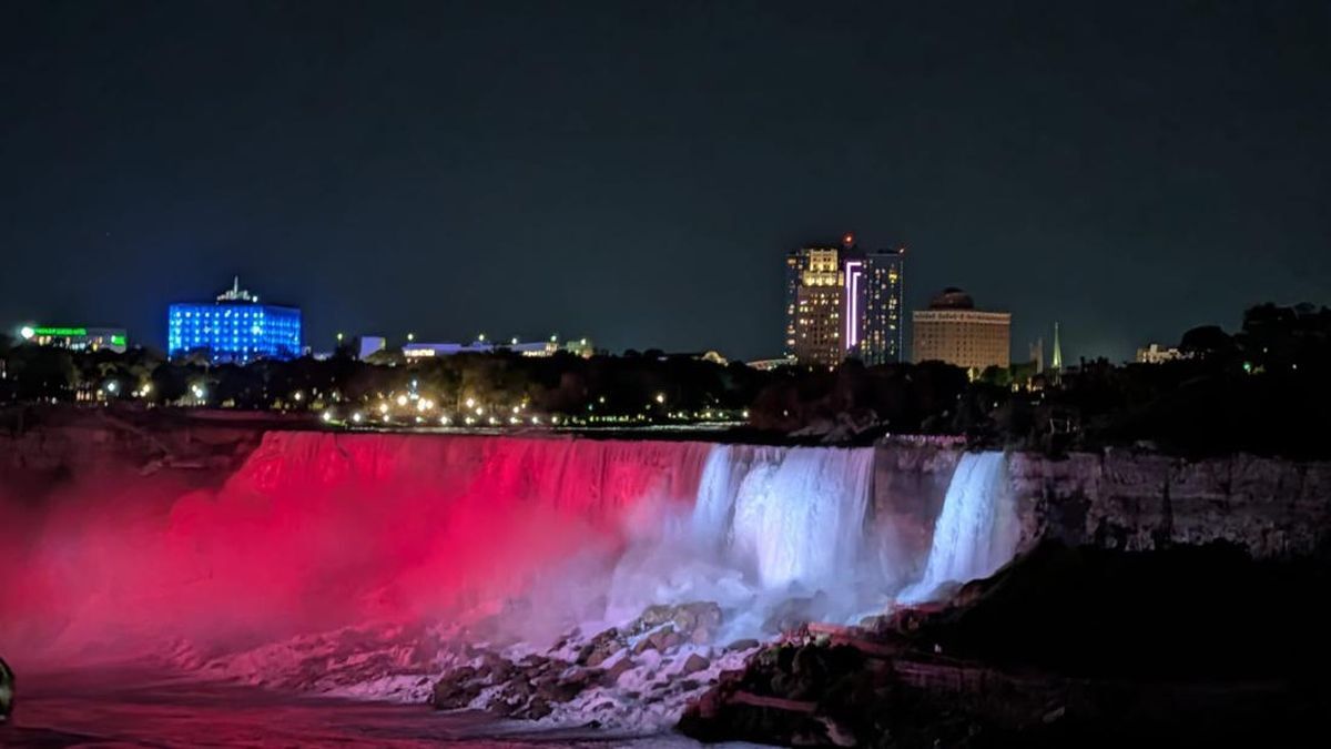Spektakuler! 81 Tahun RI, Air Terjun Niagara Dipenuhi Cahaya Merah Putih 51 Air terjun Niagara pada malam hari diterangi cahaya merah dan putih di bawah langit malam dengan latar belakang gedung-gedung kota yang bercahaya