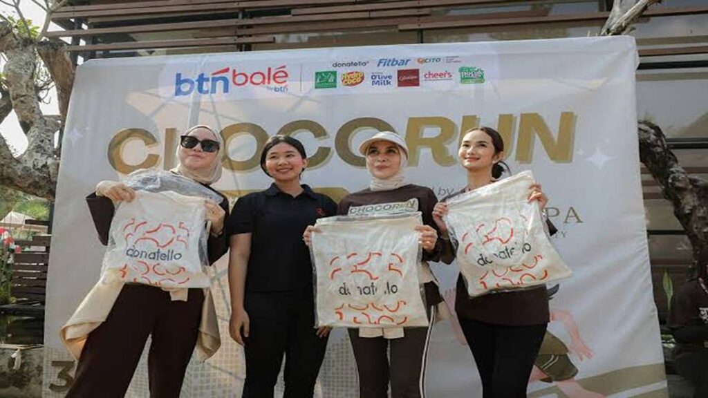 ChocoRun 2026 Sukses Digelar Yantie Rachim Perkuat Runner City 52 Chocorun 2026 Di kota Bogor Runner city, Empat wanita berpose di depan spanduk Chocorun, memamerkan tas kain bertuliskan Donatello