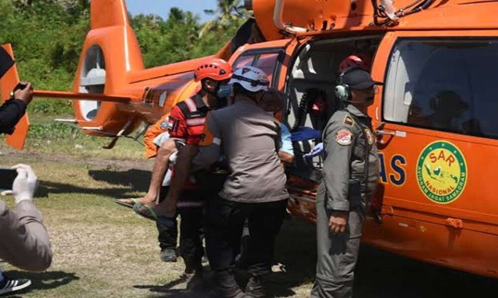 Evakuasi korban gempa di ntt, Tim penyelamat mengevakuasi korban ke dalam helikopter SAR berwarna jingga