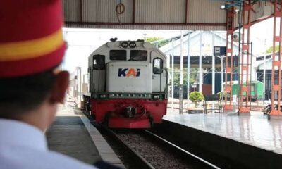 Perjalanan KA Madiun terhambat, Petugas stasiun berdiri di peron melihat lokomotif kereta api KAI yang sedang melintas di jalur rel