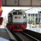 Perjalanan KA Madiun 4 Rute Resmi Terganggu Akibat Truk Mogok 53 Perjalanan KA Madiun terhambat, Petugas stasiun berdiri di peron melihat lokomotif kereta api KAI yang sedang melintas di jalur rel