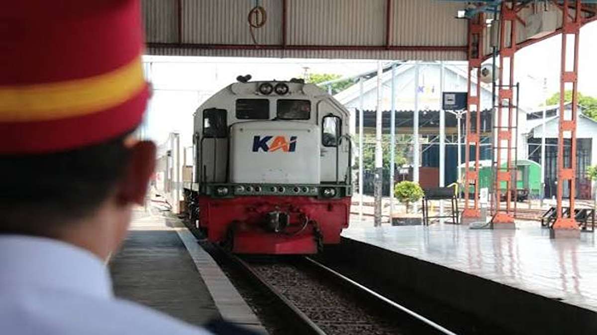 Perjalanan KA Madiun 4 Rute Resmi Terganggu Akibat Truk Mogok 51 Perjalanan KA Madiun terhambat, Petugas stasiun berdiri di peron melihat lokomotif kereta api KAI yang sedang melintas di jalur rel