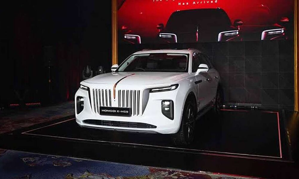 Hongqi E-HS9 Resmi Hadir SUV Listrik Mewah China Memukau, Mobil SUV listrik putih Hongqi E-HS9 dipajang di atas panggung dalam sebuah acara peluncuran