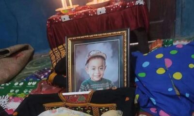 Posko Pengungsian NTT berduka akibat seorang balita meninggal dunia, Foto berbingkai seorang anak laki-laki yang tersenyum mengenakan topi dan sweter hijau, diletakkan di ruangan dengan latar belakang meja beralkas merah