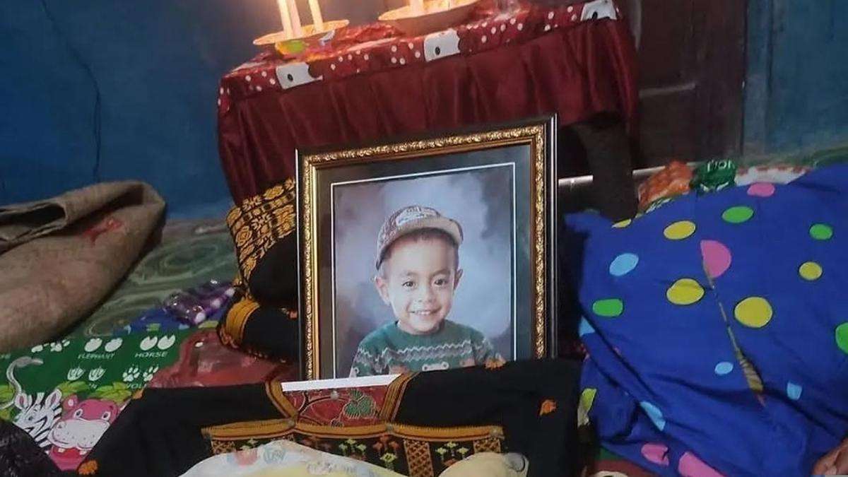 Posko Pengungsian NTT berduka akibat seorang balita meninggal dunia, Foto berbingkai seorang anak laki-laki yang tersenyum mengenakan topi dan sweter hijau, diletakkan di ruangan dengan latar belakang meja beralkas merah