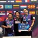 Tiga atlet badminton ganda campuran Indonesia berpose bersama medali dan plakat kemenangan Polish Open di depan latar belakang bendera-bendera negara