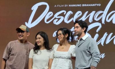 Sutradara Hanung Bramantyo bersama para pemeran berdiri di depan latar bertuliskan Descendants of the Sun