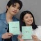 Kim Jae-young dan Nam Ji-hyun tersenyum sambil memegang naskah drama