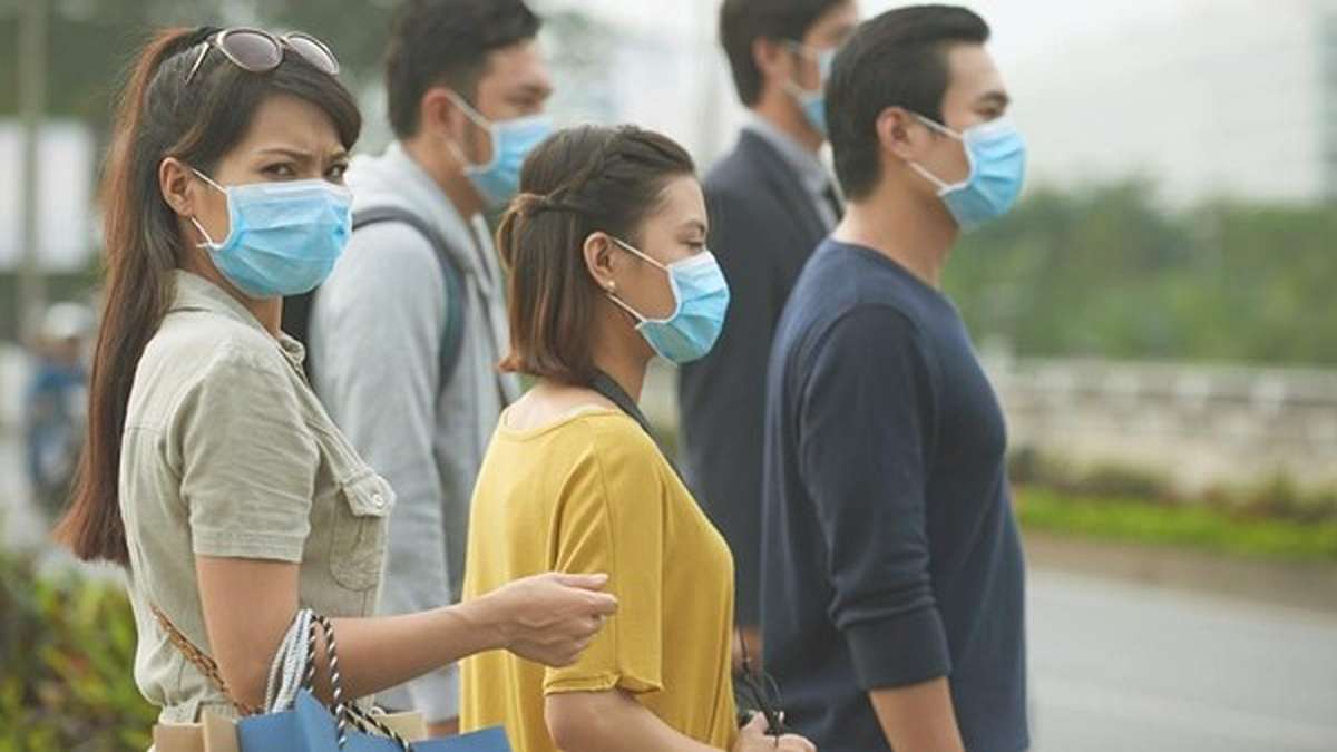 Sekelompok orang mengenakan masker medis di tempat umum