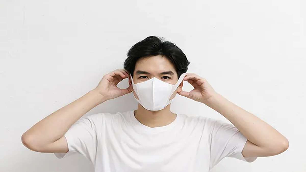 Wajib Tahu! Cara Alternatif Lindungi Diri dari Abu Vulkanik Saat Masker Langka 52 Seorang pria memakai masker wajah putih dengan latar belakang putih