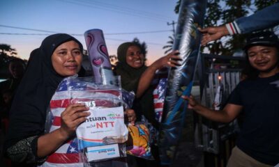 Seorang wanita berkerudung menerima paket bantuan untuk NTT yang berisi selimut dan kasa steril