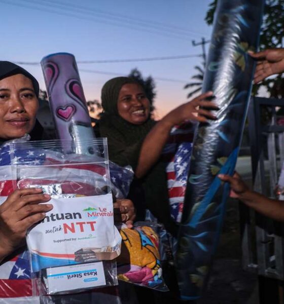 Seorang wanita berkerudung menerima paket bantuan untuk NTT yang berisi selimut dan kasa steril