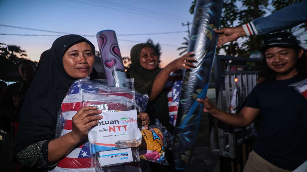 Seorang wanita berkerudung menerima paket bantuan untuk NTT yang berisi selimut dan kasa steril