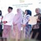 Enam orang berdiri di atas panggung menunjukkan dokumen kerja sama antara Dinas Kearsipan dan Perpustakaan Provinsi Jawa Tengah dengan PT Educa Sisfomedia Indonesia