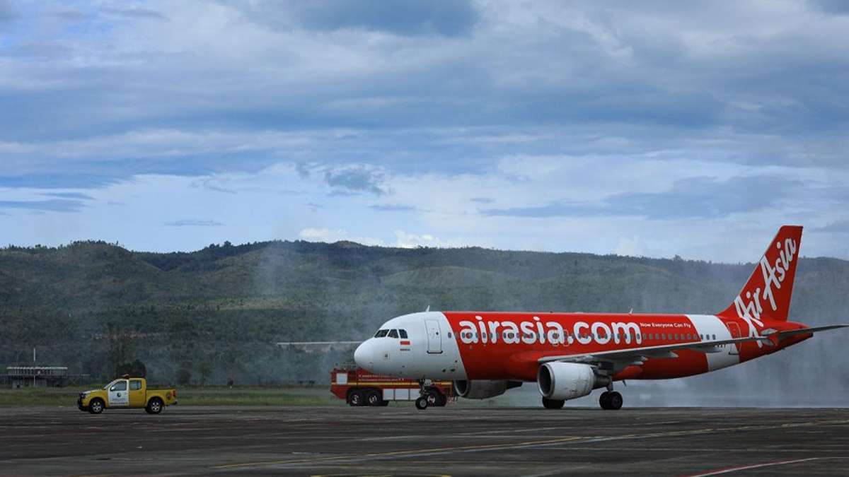 Langkah Berani, AirAsia Cari Dana Segar Triliunan Rupiah demi Restrukturisasi Keuangan 52 Pesawat AirAsia terparkir di landasan pacu dengan latar belakang pegunungan dan langit berawan