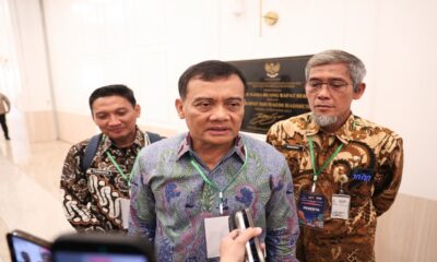 Tiga orang pria mengenakan kemeja batik dan tanda pengenal, berdiri berdampingan saat wawancara