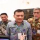 Tiga orang pria mengenakan kemeja batik dan tanda pengenal, berdiri berdampingan saat wawancara