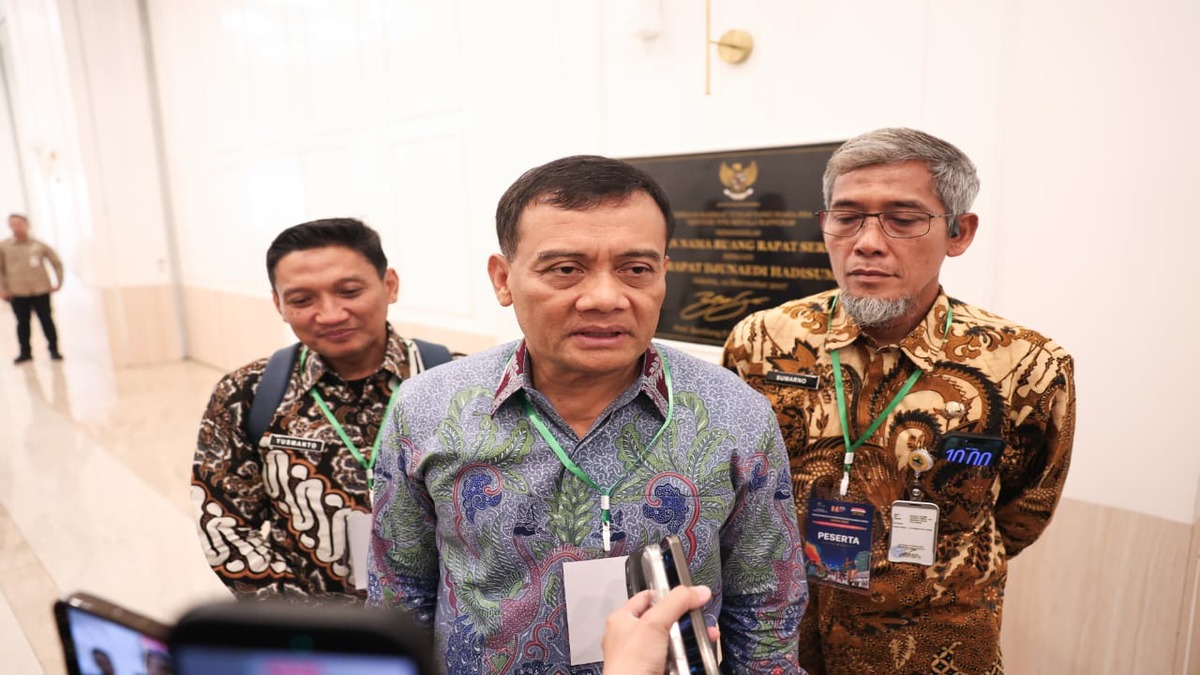 Tiga orang pria mengenakan kemeja batik dan tanda pengenal, berdiri berdampingan saat wawancara