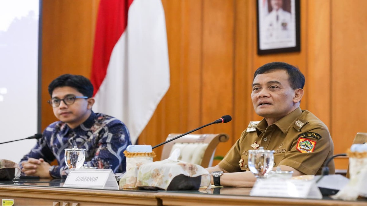 Terobosan! PSEL Semarang Raya Targetkan Olah 1.000 Ton Sampah Jadi Listrik 51 Nana Sudjana mengenakan pakaian dinas saat menghadiri rapat dengan latar belakang bendera merah putih