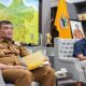 Waspada! Harga Beras Naik, Luthfi Instruksikan Intervensi Pasar 57 Dua orang pria sedang duduk di sofa sambil memegang dokumen di ruangan berlatar belakang peta dan rak pajangan