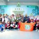 Kontingen Papua Barat Daya berfoto bersama dengan latar belakang spanduk Musabaqah Tilawatil Quran dan memegang bendera kontingen
