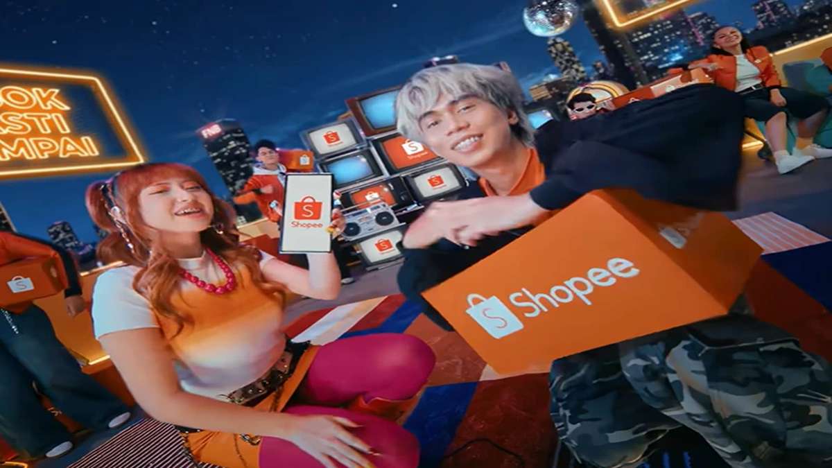 Spektakuler! Shopee x Naykilla Tenxi Ramaikan FYP, Tembus 21 Juta Views di TikTok 53 Dua orang menampilkan kotak pesanan Shopee di set panggung dengan latar belakang kota malam hari