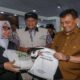 Fantastis! Pameran MTQ Nasional Catat Transaksi UMKM Rp500 Juta per Hari 54 Gubernur Ahmad Luthfi menyerahkan tas belanja putih kepada seorang perempuan berkacamata dan berhijab dalam sebuah acara