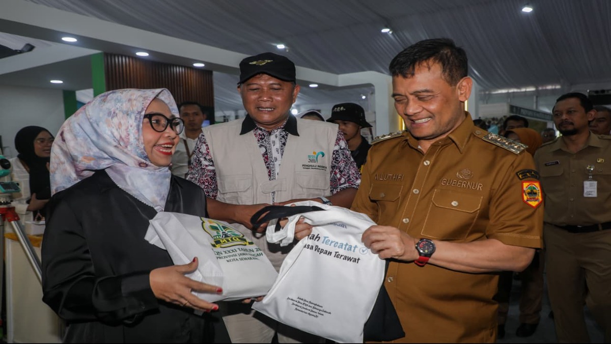 Fantastis! Pameran MTQ Nasional Catat Transaksi UMKM Rp500 Juta per Hari 51 Gubernur Ahmad Luthfi menyerahkan tas belanja putih kepada seorang perempuan berkacamata dan berhijab dalam sebuah acara