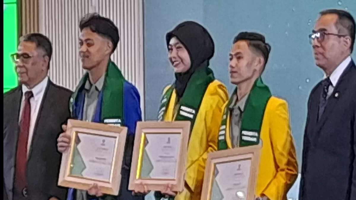 Lima orang berdiri berdampingan sambil memegang piagam penghargaan di atas panggung